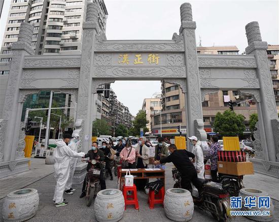  4月16日，進(jìn)出武漢漢正街步行街的人員在掃描健康碼。新華社記者 王毓國 攝